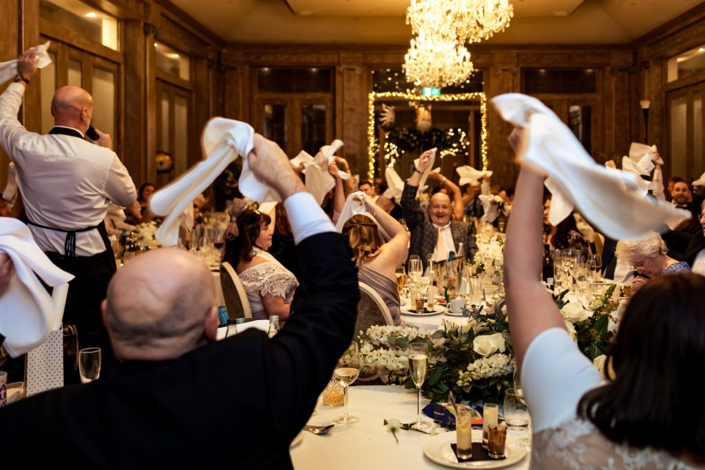 singing waiters waving Napkins in the air as the guests sing